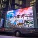 Video van against London office towers, showing spoof disaster film trailers to highlight climate impact of fossil fuel projects underwritten by insurance CEOs
