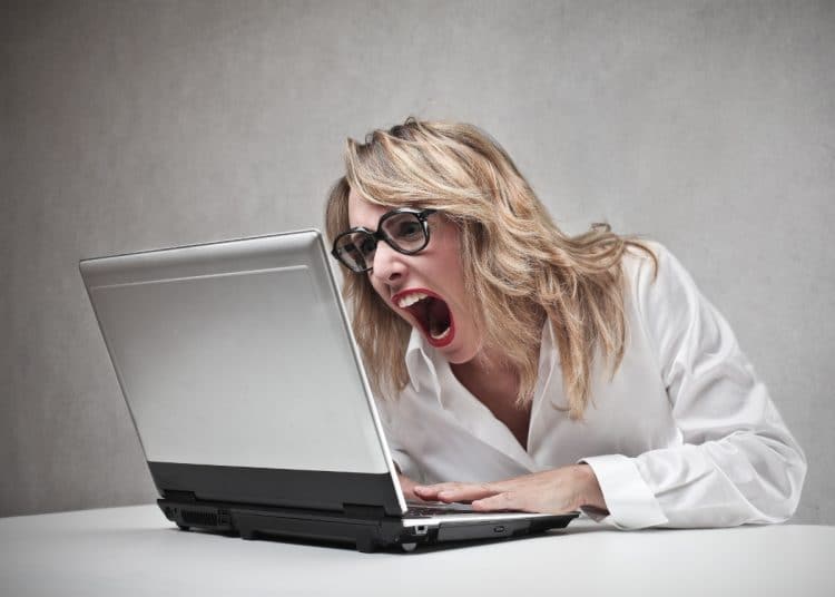 Blonde woman shouts at laptop. Racist Word of the Year 2025