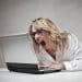 Blonde woman shouts at laptop. Racist Word of the Year 2025
