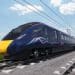 A navy blue train against a blue sky on a grey rail track