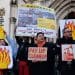Filipino campaigners outside the Royal Courts of Justice holding signs that say Pay Up Clean Up and Make Polluters Pay For Climate Damage