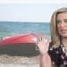 Katie Hopkins in front of a dinghie on a beach
