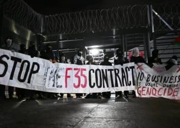 Protesters outside Leonardo arms factory Edinburgh holding banner saying Stop The F35 Contract
