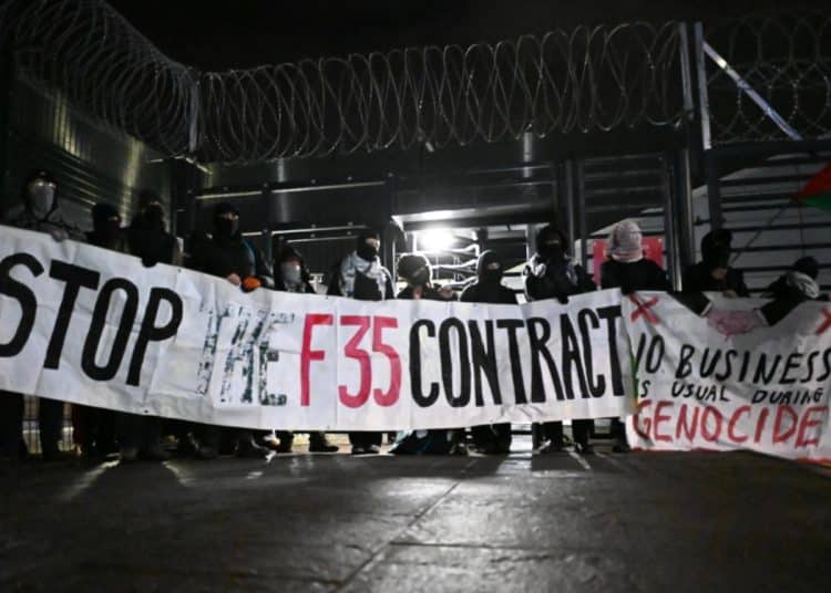 Protesters outside Leonardo arms factory Edinburgh holding banner saying Stop The F35 Contract