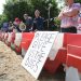 A protest at a beagle breeding facility. A placard says Please Give Us The Dogs