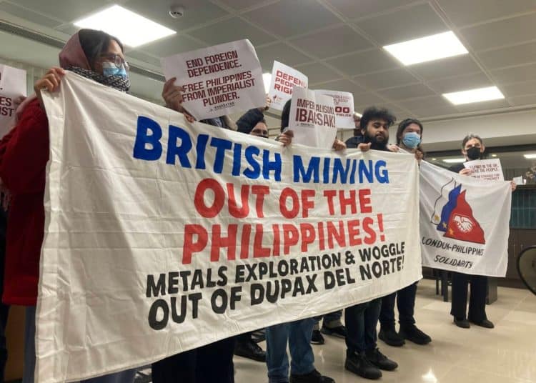 Activists hold a banner saying British Mining Out Of The Philippines!