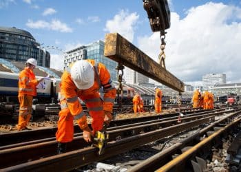 Network Rail workers in orange hi-vis overalls and white hard hats