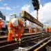 Network Rail workers in orange hi-vis overalls and white hard hats