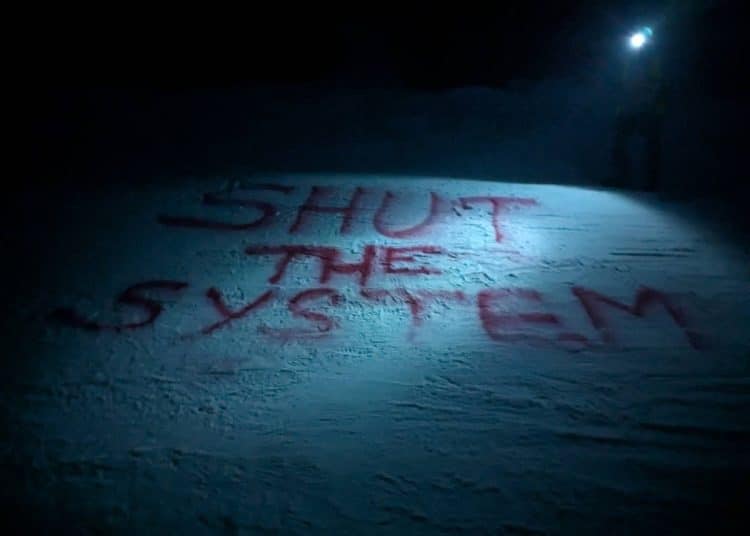 Shut The System written in red on a ski slope in Davos