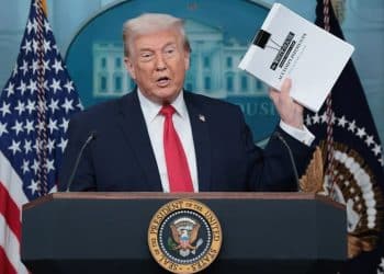 Donald Trump holding a paper titled Accomplishments on 20 January 2026