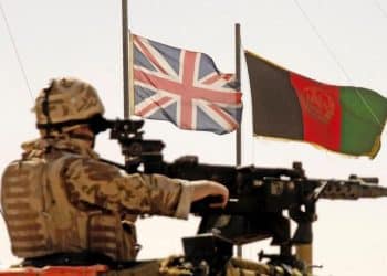 UK military in Afghanistan. A gunner in front of a union flag and an Afghan flag Paul Dixon