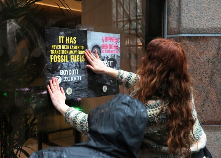Campaigners flyposting at an office of Zurich Insurance Group