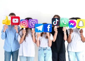 Stock image of children with their faces hidden by logos of social media platforms