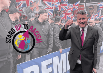 Leader of Britain First, Paul Golding in front of a crowd of far right. The Stand Up to Racism logo is in on the left hand side.