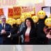 Keir Starmer and Angeliki Stogia with people standing behind them with the grimacing face, Labour