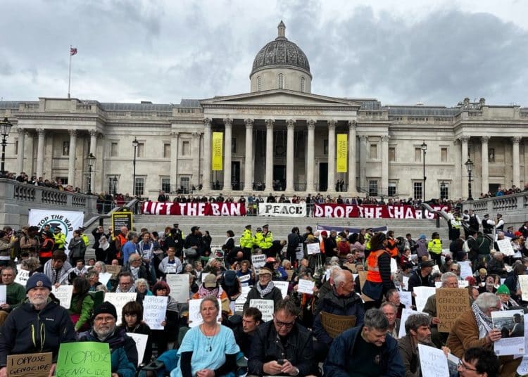 Defend Our Juries protest in Trafalgar Square. Banner reads Lift The Ban Peace Drop The Charges Unity Against Genocide