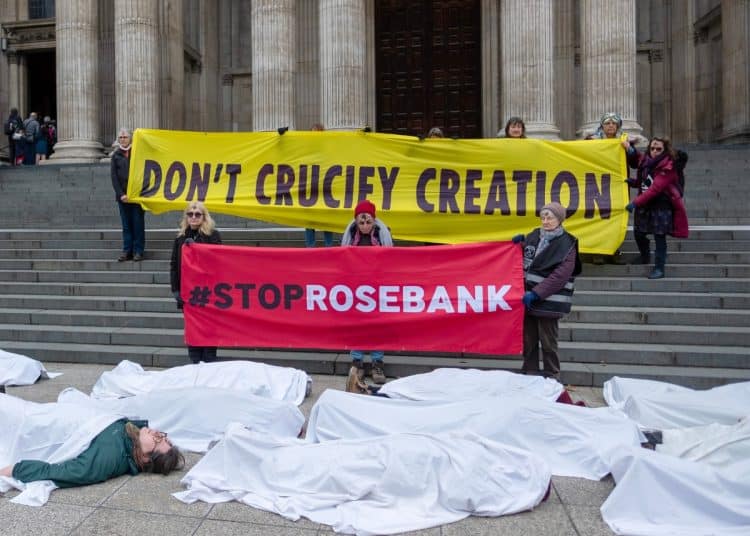 Banners outside St Paul's saying Don't Crucify Creation and Stop Rosebank with people under white shrouds in front