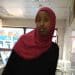 Zahwa Salah Mukhtar dressed in a red hijab and black dress