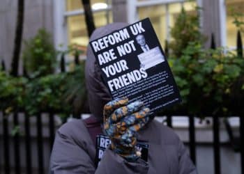 Protester holds flyer saying Reform UK Are Not Your Friends at launch of Reform Jewish Alliance