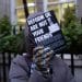 Protester holds flyer saying Reform UK Are Not Your Friends at launch of Reform Jewish Alliance