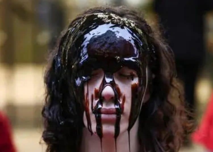 Activist covered in treacle in protest against oil company Equinor