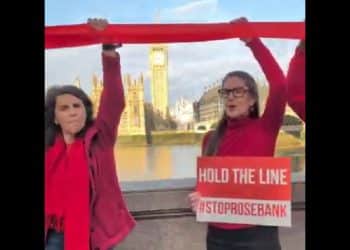 Fossil Free London protesters across the Thames from parliament hold a red ribbon and a sign saying Hold The Line #StopRosebank Rosebank