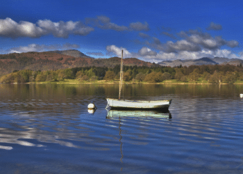 Scenic landscape photo of a boat in the middle of Lake Windermere, Cumbria
