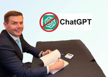 Reform member Matt Goodwin sits at a desk smiling. A 'No ChatGPT' logo is in the background of the photo