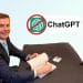 Reform member Matt Goodwin sits at a desk smiling. A 'No ChatGPT' logo is in the background of the photo