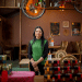 Moitra Sarkar stands in her restaurant, where ICE agents raided without reason. She's standing underneath a bicycle hanging from the ceiling and looks determined
