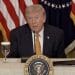 US president Donald Trump speaking at a microphone