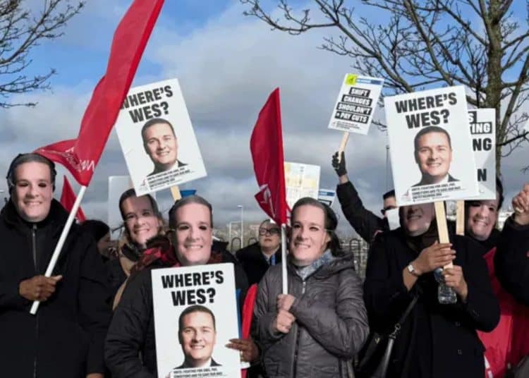 Protesters wearing Wes Streeting masks hold signs saying Where's Wes?