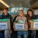 3 people take boxes of food to foodbanks. The boxes are labelled Take Back Power These Things Are Going To Those Who Need Them