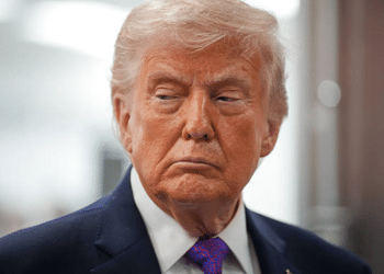 US president Donald Trump with his mouth slightly curled, looking stern with his gaze down and slightly away