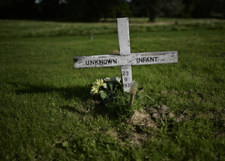 DWP cutting benefits of women who received compensation after surviving mother and baby homes - image shows an unmarked infant grave with a cross that reads 'unknown infant'