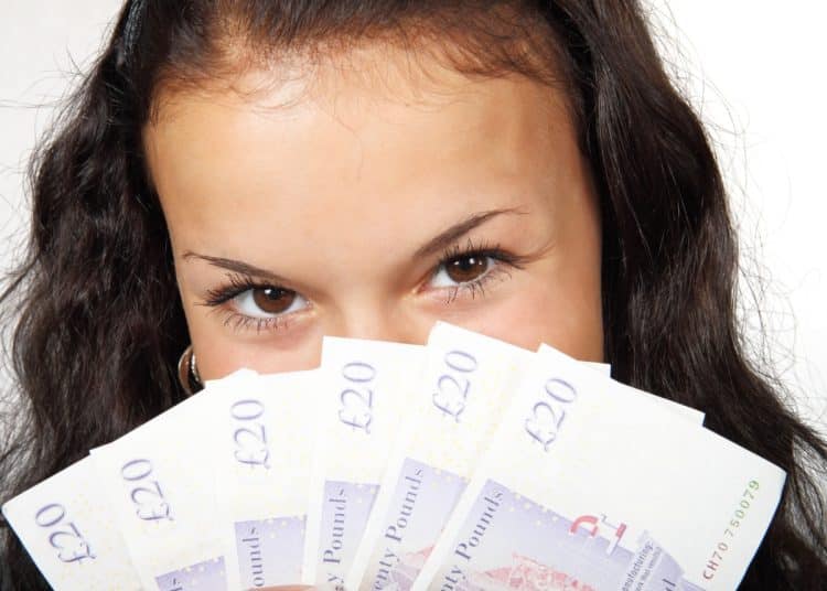 Young woman holding £20 notes Youth minimum wage