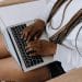 Woman uses her laptop which is rested on her outstretched legs - DWP