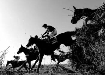 Horses jumping a fence at Aintree