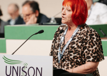 Andrea Egan speaking at the 2026 Unison health conference wearing her Unison lanyard and standing infront of a mic