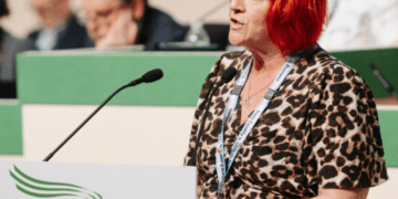 Andrea Egan speaking at the 2026 Unison health conference wearing her Unison lanyard and standing infront of a mic