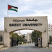 Education in Palestine: The outside of Birzeit University, where the university's name is affixed at the top of a stone archway, with a proud Palestine flag flying above