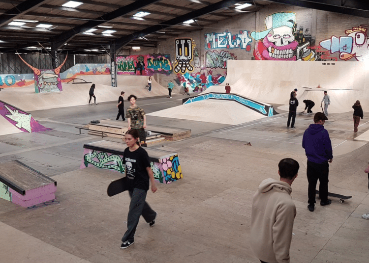 A mock-up photograph of what the Flo Skatepark would look like once opened with graffitti on the walls and young people walking over ramps with their skateboards