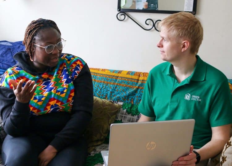 Green Doctors project manager, Daniel Brittle, holding a laptop, speaking to service user Pearl.