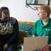 Green Doctors project manager, Daniel Brittle, holding a laptop, speaking to service user Pearl.