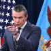 Pete Hegseth points at someone or something with his index finger