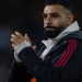 Liverpool player, Mo Salah, claps his hands together and looks somewhat morose looking on in the distance
