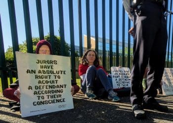 Protesters hold placards outside Woolwich Crown Court