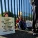 Protesters hold placards outside Woolwich Crown Court