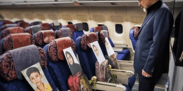 A man looks at photos of the children lost in the Minab tragedy in Iran