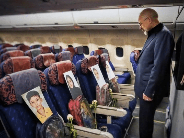 A man looks at photos of the children lost in the Minab tragedy in Iran
